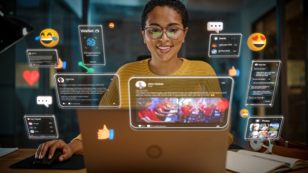 Persona frente a una laptop sonriendo mientras usa una interfaz virtual con íconos de redes sociales, mensajes y datos digitales flotando en la pantalla.