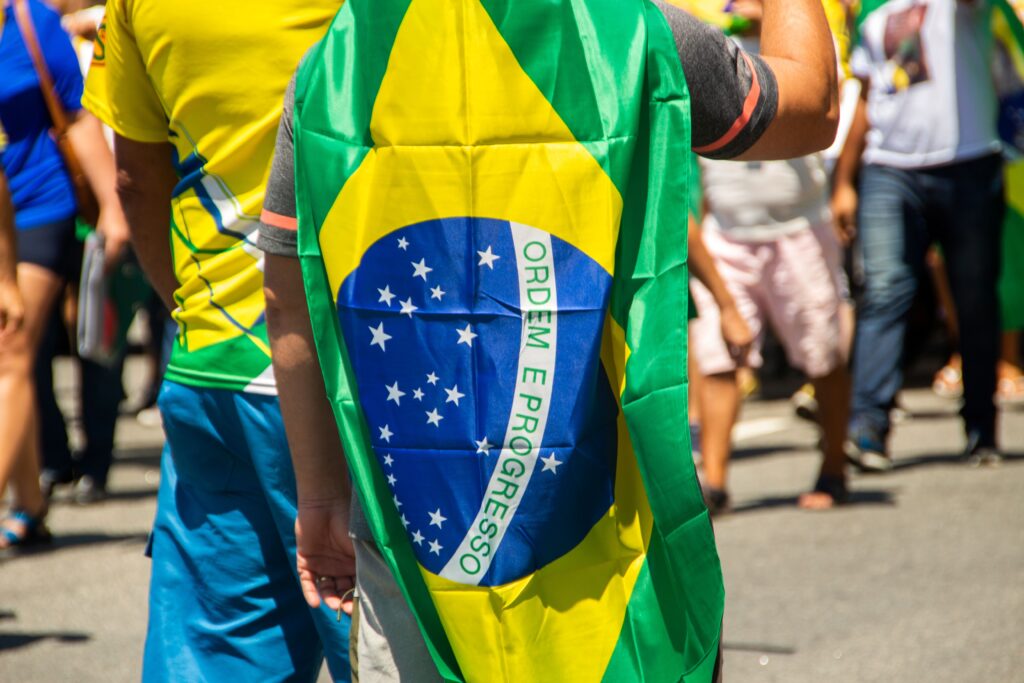 Manifestantes en protesta sindical en Brasil, con personas portando la bandera nacional y caminando por la calle en una movilización.