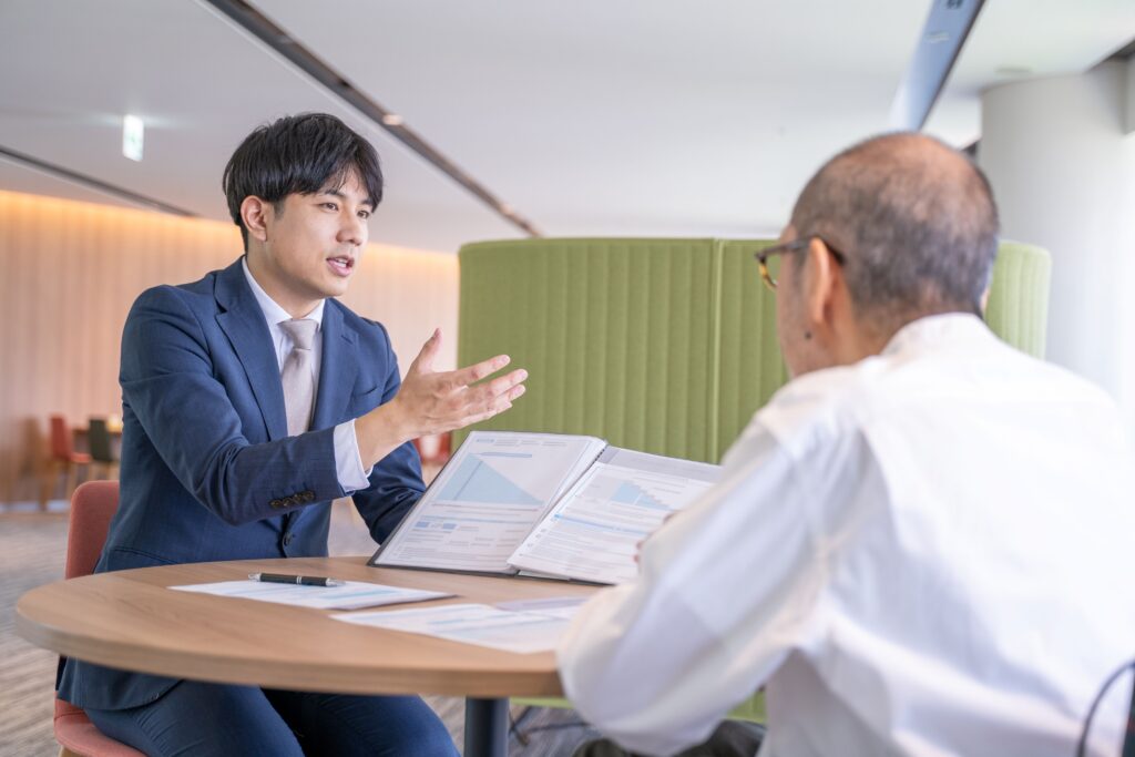 Asesor financiero explica proyecciones de retiro a un adulto mayor, ilustrando la cobertura del sistema de china pensiones y el crecimiento de la seguridad social.