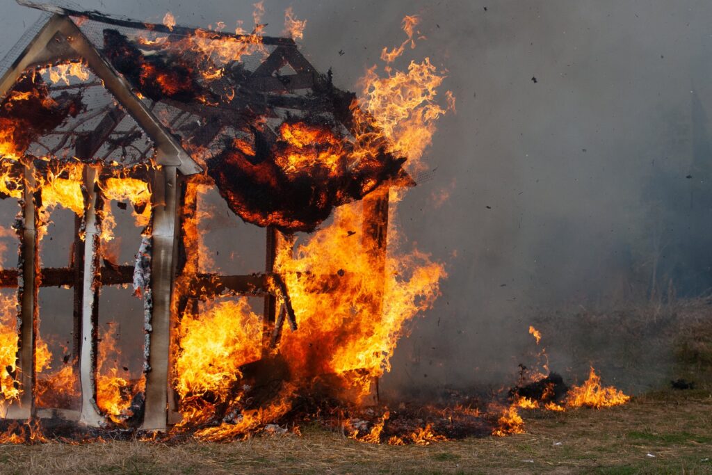 Casa de madera en llamas durante incendios en Andalucía que afectan empleo rural, brigadistas y seguridad laboral en la región