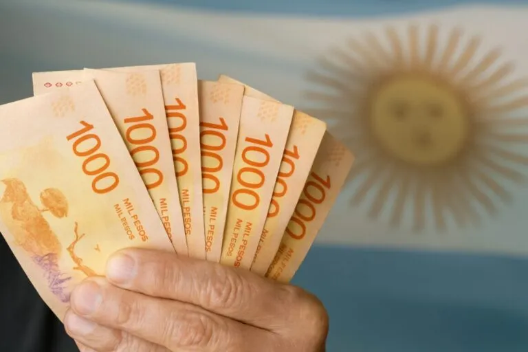 Trabajador argentino revisa sus finanzas personales en un entorno humilde