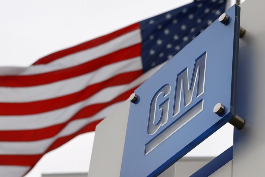 Fotografía editorial que muestra a trabajadores automotrices en la planta de GM Lansing durante un día de cierre