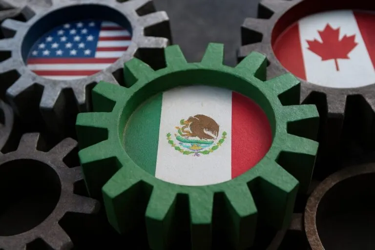 Vista de trabajadores frente a una planta industrial, en contexto de violaciones a obligaciones laborales bajo el T-MEC