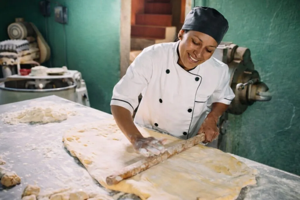 Trabajadora mexicana emprendedora en panadería artesanal, representando el emprendimiento laboral como alternativa al empleo formal