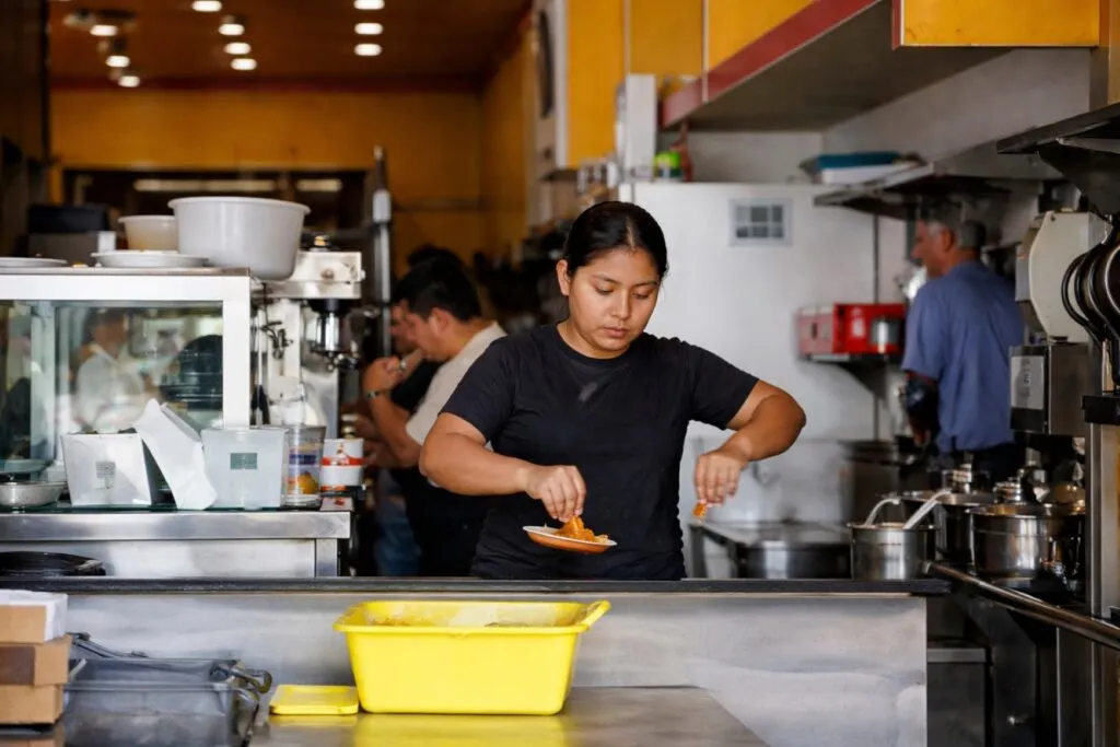 Imagen profesional de empleados y empresario frente a reloj laboral y documentos sobre jornada laboral de 40 horas en México