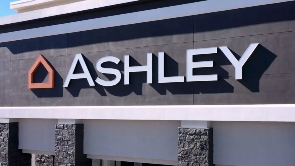 Trabajadores industriales frente a una fábrica tras el anuncio del cierre de planta y despidos en Ashley Furniture en Texas