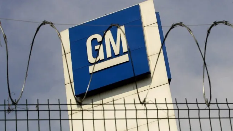 logo de General Motors en planta automotriz en México con cerca de seguridad, relacionado con negociación sindical y posible huelga laboral