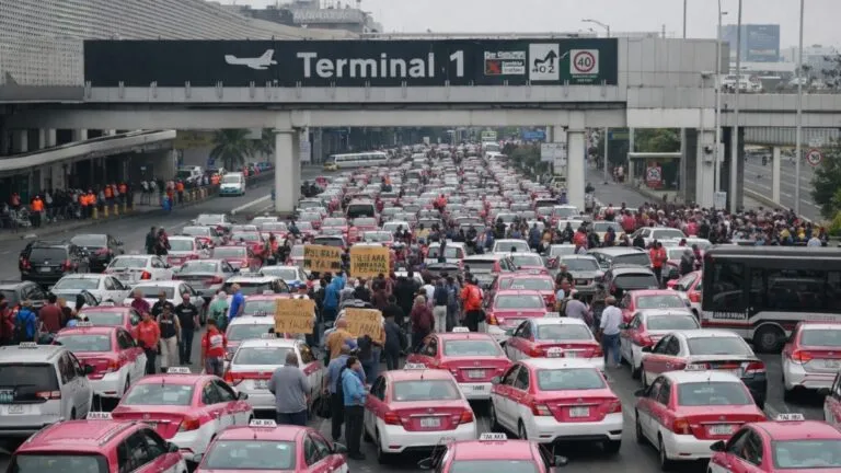 Taxistas bloqueando accesos al Aeropuerto Internacional de la Ciudad de México durante protesta contra servicios por aplicación