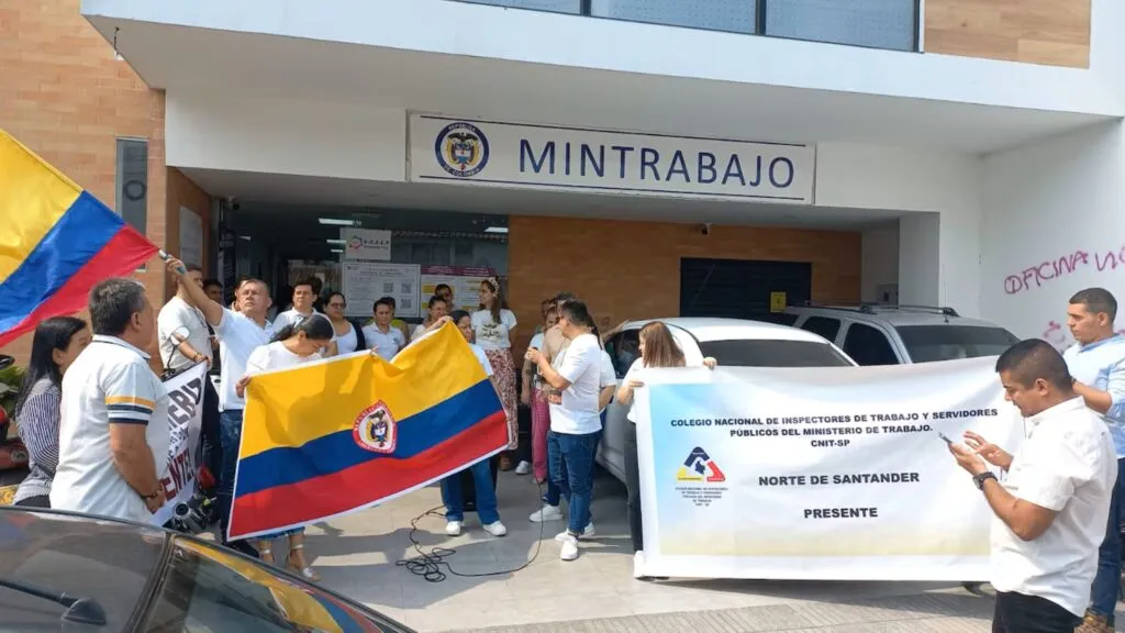 beneficios a sindicatos en Colombia con trabajadores organizados en reunión laboral y debate sobre reforma del gobierno