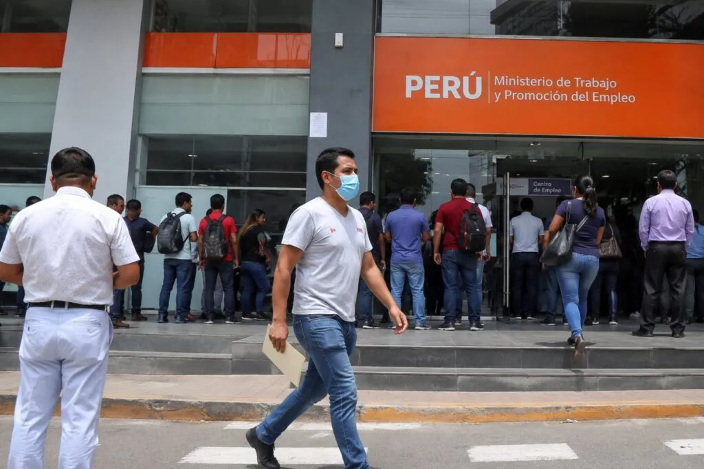 Trabajadores en una oficina durante una jornada laboral relacionada con el nuevo régimen laboral en Perú y beneficios progresivos.