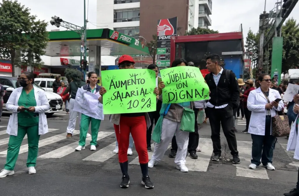 Trabajadores del IMSS realizan una manifestación en una avenida de Ciudad de México para exigir mejoras laborales y cambios sindicales.