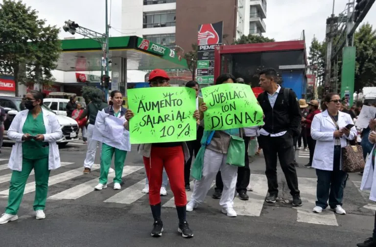 Trabajadores del IMSS realizan una manifestación en una avenida de Ciudad de México para exigir mejoras laborales y cambios sindicales.